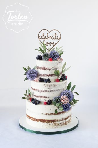 Hochzeitstorte - Semi Naked Cake, dekoriert mit Disteln, Olivenzweigen, Brombeeren, Himbeeren und einem Cake Topper „Celebrate Love“
