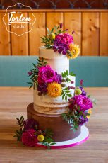 Hochzeitstorte - Semi Naked Cake mit einer Etage Ganache, dekoriert mit Blumen in kräftigen Farben: Dahlien, Rosen, Hortensien, Pistazienblätter