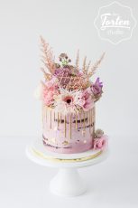 Rosa Semi Naked Cake mit goldenem Drip, Blattgold, einem Happy Birtday Topper und üppiger Blumendeko