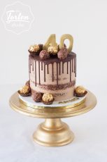 Schokolade-Semi Naked Cake mit Schokodrip, dekoriert mit Ferrero Rocher, einem goldenen 40 und dem Namen