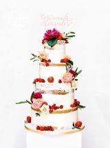 Vierstöckiger semi Naked Cake mit roten Beeren und Blumen
