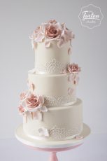 Dreistöckige Hochzeitstorte in Ivory, dekoriert mit essbarer Spitze und Zuckerrosen in Altrosa