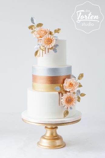 Dreistöckige Hochzeitstorte mit Gold, Silber und Kupferstreifen bemalt, dekoreirt mit Zuckerblumen in Aprikot, Schokodrip in Kupfer, silber und goldenen Blättern