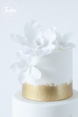 Ausschnitt Zuckerblumen von Dreistöckige weiße Torte, Gold gemalt am Fuß der Etagen