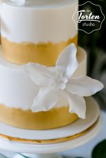 Ausschnitt Zuckerblumen von zweistöckige weiße Torte, Gold gemalt am Fuß der Etagen